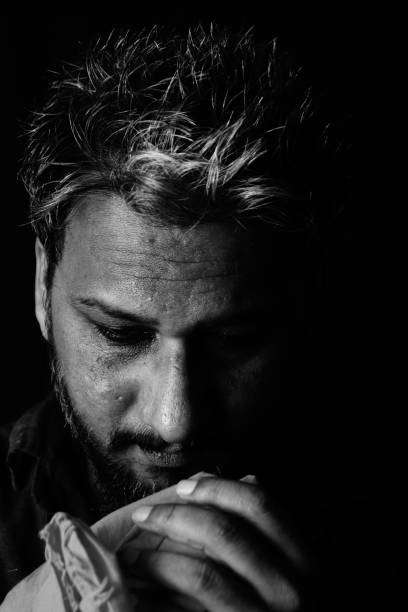 istock Grayscale portrait of a man with hands with fabric on it looking down 1440967235