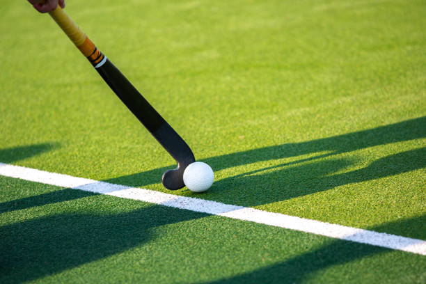 Field hockey player on artificial grass play field.