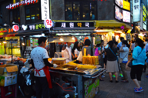 Seoul, South Korea – July 20, 2016: A man selling street food in the middle of busy Myeongdong district