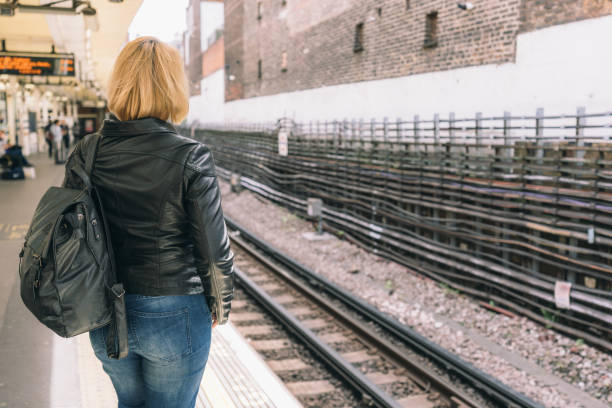 istock Rear view of a young female with a backpack standing on the platform 1440969515