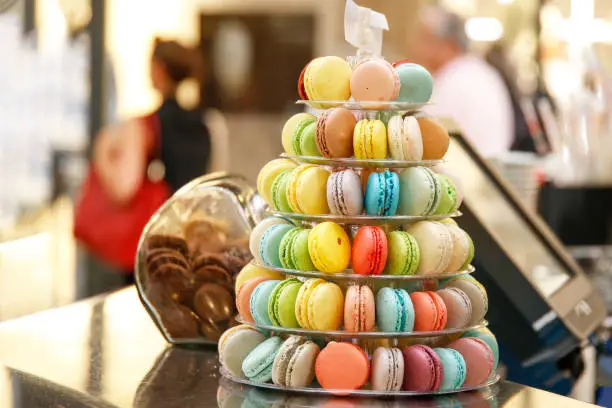 colorful green yellow red blue chocolate macarons in a lovely street cafe in the lively streets in central Rome.