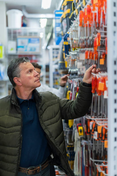 istock Store clerk helps his customer find the tools he is looking for in the store 1440969964