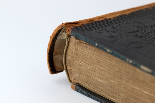 A closeup shot of an old antique book with a broken spine