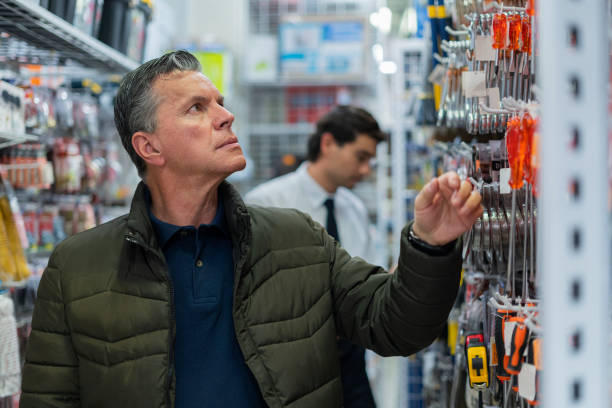istock Store clerk helps his customer find the tools he is looking for in the store 1440970149