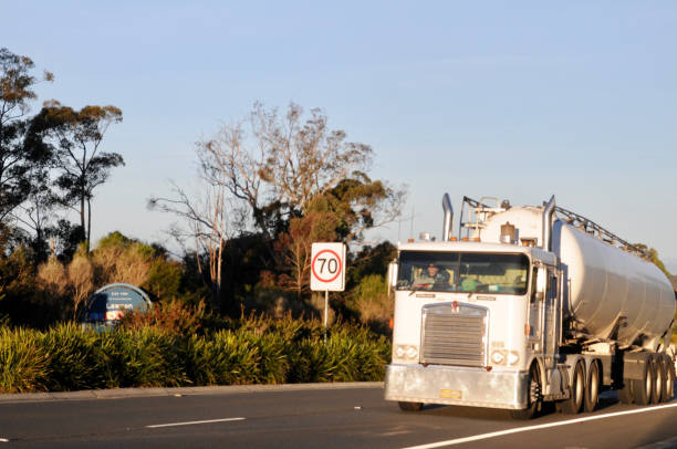 Large semi truck hauling freight on the open highway in the western USA under a morning sky.
