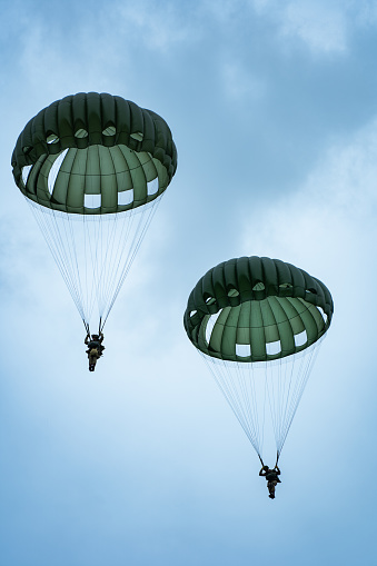 saint mere eglise, France – July 13, 2019: A vertical shot of US soldiers parachuting during the D-day reenactment in France