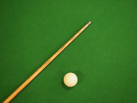 Sports game of billiards on a green cloth. one cue and a cue ball on a pool table. Billiards billiard balls.