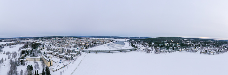 A panoramic shot of buildings and a railway bridge over Ounasjoki River in Rovaniemi, Finland