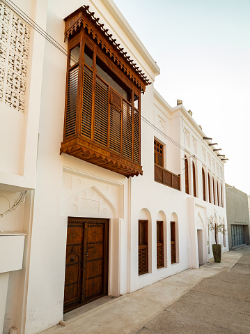 Toma vertical de edificios de paredes blancas con balcones de madera mashrabiya photo