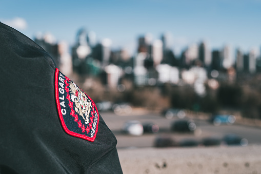 Calgary, Canada – March 17, 2022: Police shoulder patch with the city scape blurred in the background