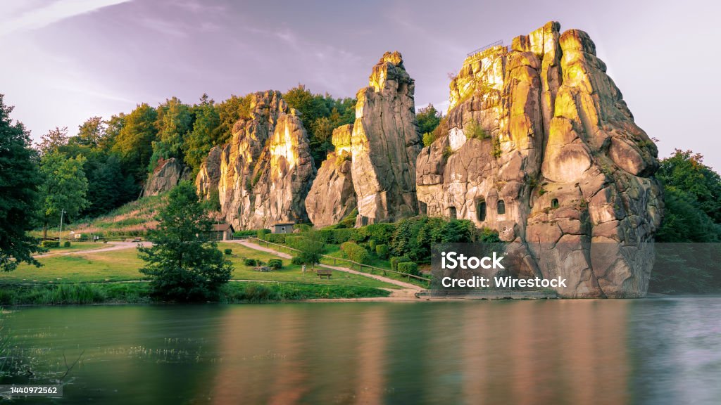 Externsteine rocks on the shore of Wiembecke in the Teutoburg Forest in Detmold, Germany The Externsteine rocks on the shore of Wiembecke in the Teutoburg Forest in Detmold, Germany Canyon Stock Photo