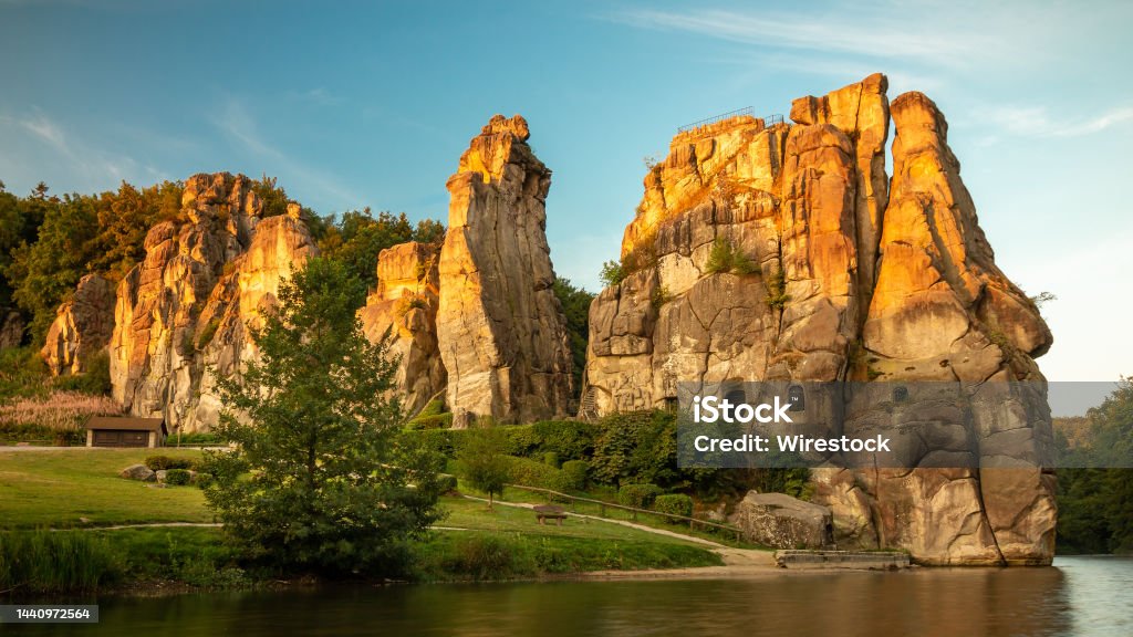 Externsteine rocks on the shore of Wiembecke in the Teutoburg Forest in Detmold, Germany The Externsteine rocks on the shore of Wiembecke in the Teutoburg Forest in Detmold, Germany Bay of Water Stock Photo