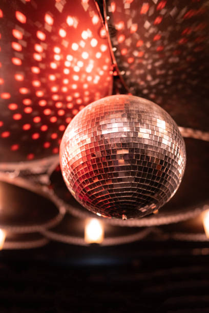 istock Shallow focus of a red disco ball spinning under bright disco lights retro 1440972879