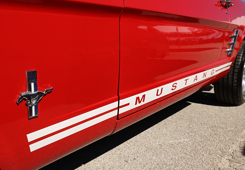 San Anton, United States – March 16, 2022: A closeup shot of Logo design on a 1966 Ford Mustang looking down the driver's side of the car at cars show in San Anton, United states