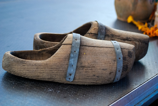 A closeup of a pair of wooden shoes on the floor