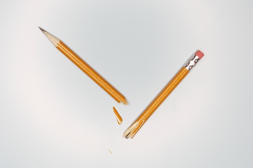 Colored crayons arranged in a circle against a white background. Table top view, flat lay.