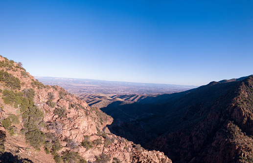A large rocky mountains with trees around hilly desert area in Jerome, Arizona, USA