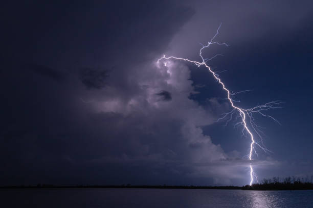 istock Stormy purple sky with striking lightning over water in Florida 1440975059
