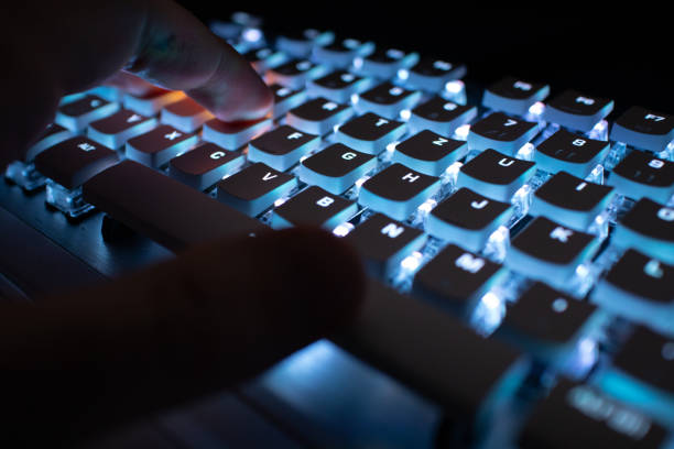 istock Male's hand typing on a keyboard with light up keys 1440977723
