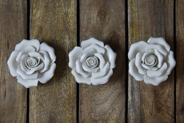 The white ceramic roses on wooden background