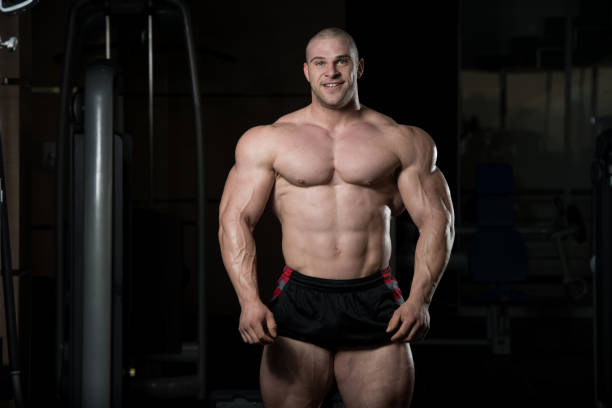 Portrait Of A Physically Fit Muscular Young Man Handsome Young Man Standing Strong In The Gym And Flexing Muscles - Muscular Athletic Bodybuilder Fitness Model Posing After Exercises bodybuilder stock pictures, royalty-free photos & images