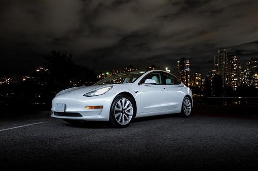Vancouver, Canada – September 13, 2021: A Tesla Model 3 at night Vancouver City by the public boat ramp