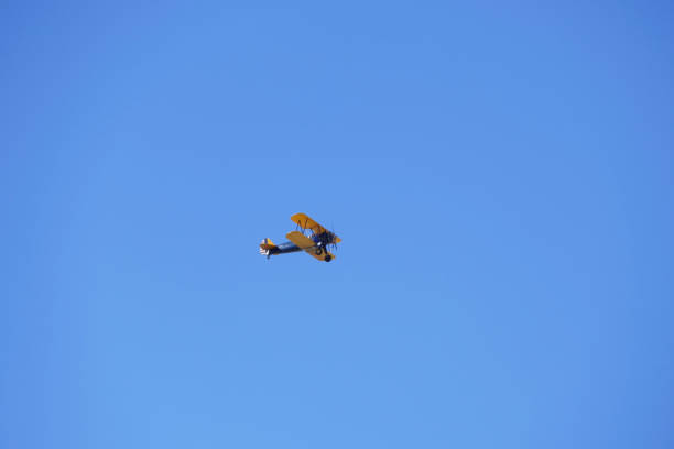 istock Vintage propeller biplane flying in a clear blue sky 1440978759