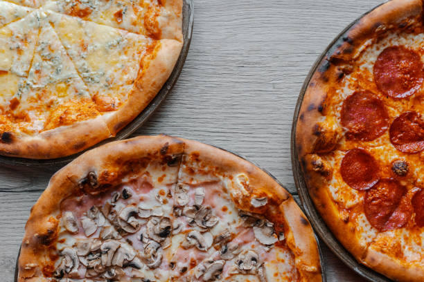 istock Photo of multiple pizzas on table 1440979476