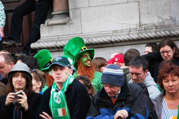 American hunk waring a fun disguise for a St-Patrick's day party with a huge red-head wig, green glasses and clover necklace.