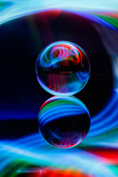 istock Glass ball with a reflection isolated on a colorful background 1440980596