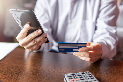 Woman using smartphone with credit card, ordering online shopping. Working from home concept, copy spac