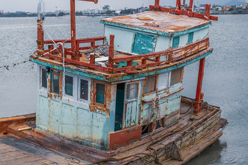 Satthahip, Thailand – March 03, 2022: An old squid fisherboat parked in Bang Sare, Thailand