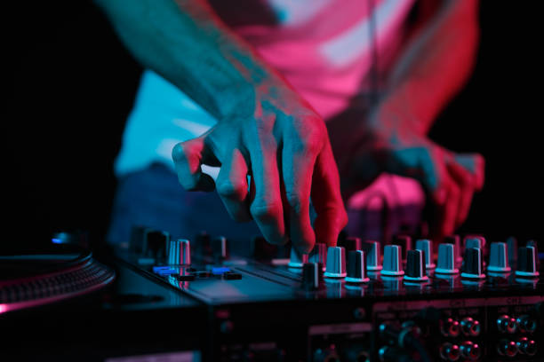 istock Disc jockey mixing techno music on rave party. Disk jokey adjusting volume frequency regulator on professional sound mixer device 1440981110