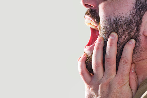 man on gray background with beard and screaming with mental disorders