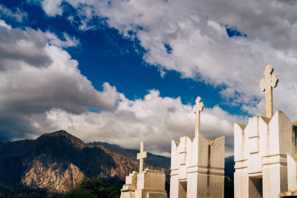 istock Cemetry with white gravestones with cross during a cloudy day 1440982196