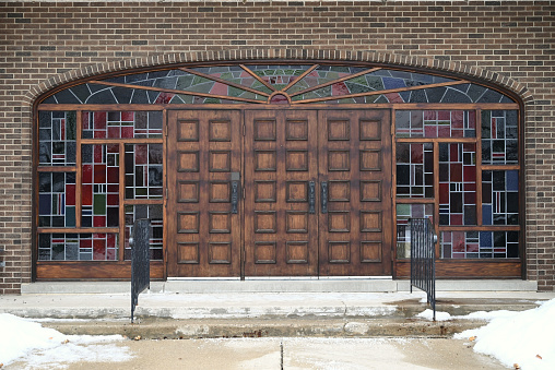 A symmetric shot of the facade of a church with wooden doors, stained windows and brick walls in Hespeler, Ontario, Canada