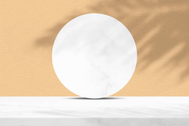 istock White Marble Table and Circle Marble Partition with Coconut Leaf Shadow on Brave Ground Brown Concrete Wall Texture Background, Suitable for Cosmetic Product Presentation Backdrop, Display, and Mock up. 1440982766