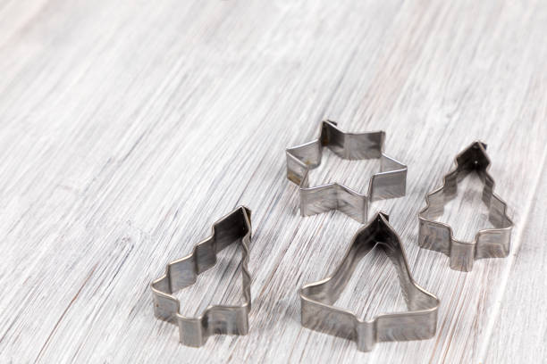 Steel Christmas cookie cutters on a wooden background