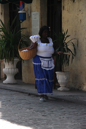Cuba - La Havane - August 6, 2019 -street scene - beautiful woman - itinerant peanut seller in traditional costume who is walking in the street of the old Havane to sell peanuts