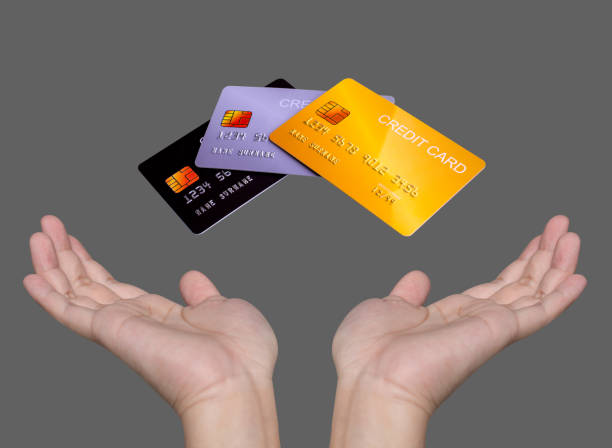 istock Hand showing credit card isolated on grey background. 1440985810