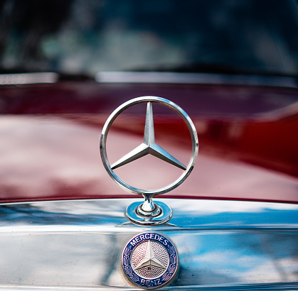 ZOETERMEER, Netherlands – July 05, 2021: A closeup of the Mercedes Benz logo close up on a red car