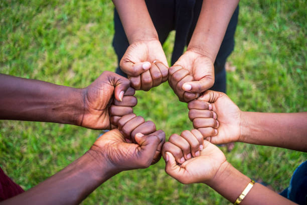 istock Teamwork concept with different skin color people touching their fists 1440986177