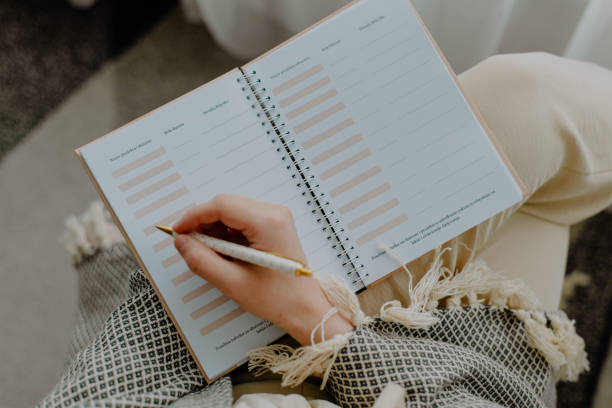 istock Top view of a female hand with pen writing notes in a journal 1440987084