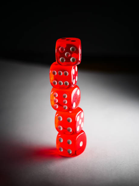 istock Vertical closeup shot of a stack of red die 1440987321
