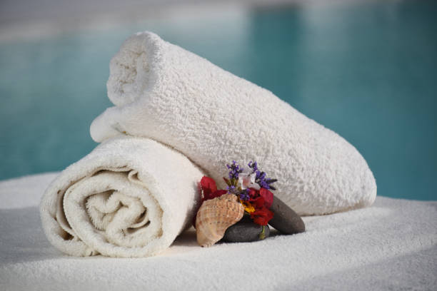 istock Rolled towels, stones, and a shell on the poolside 1440987427