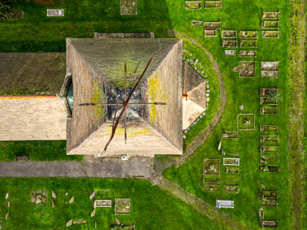 vista drone dall'alto verso il basso di un'alta guglia della chiesa che mostra la banderuola e il piombo decorati. - roof roof tile rooster weather vane foto e immagini stock