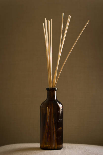 istock Dark glass diffuser bottle with natural reed sticks put on a pillow 1440989446