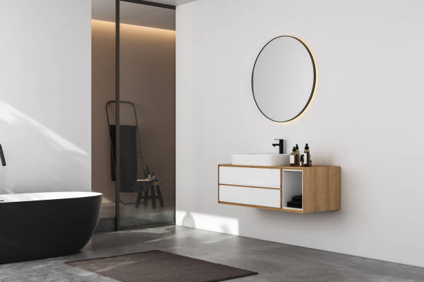 istock Modern minimalist bathroom interior, modern bathroom cabinet, white sink, wooden vanity, interior plants, bathroom accessories, bathtub and shower, white and beige walls, concrete floor. 3d rendering 1440993547