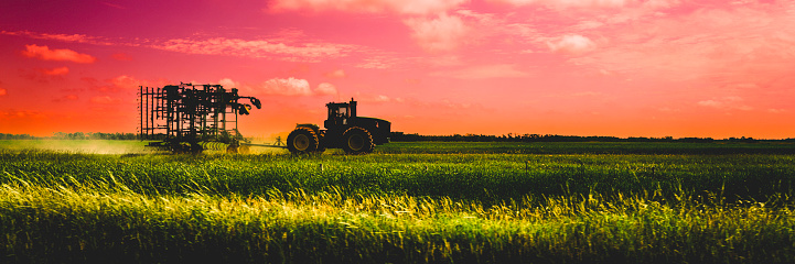 Sunset agricultural field landscape with tractors in Winnipeg, Manitoba, Canada