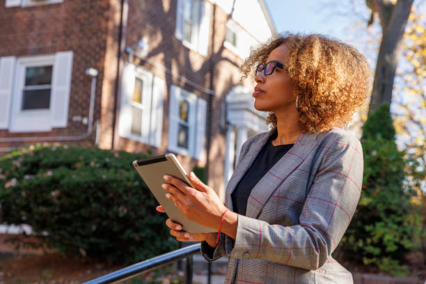 Female real estate appraiser, examining the townhouse in Queens, New York. stock photo